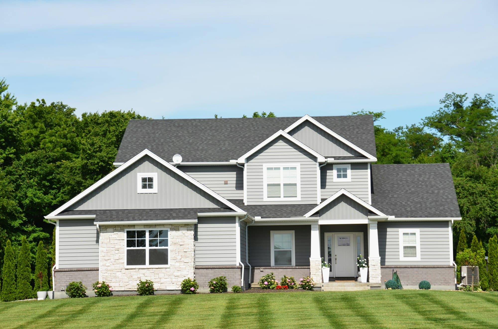 Freshly striped lawn in front of a two-story house