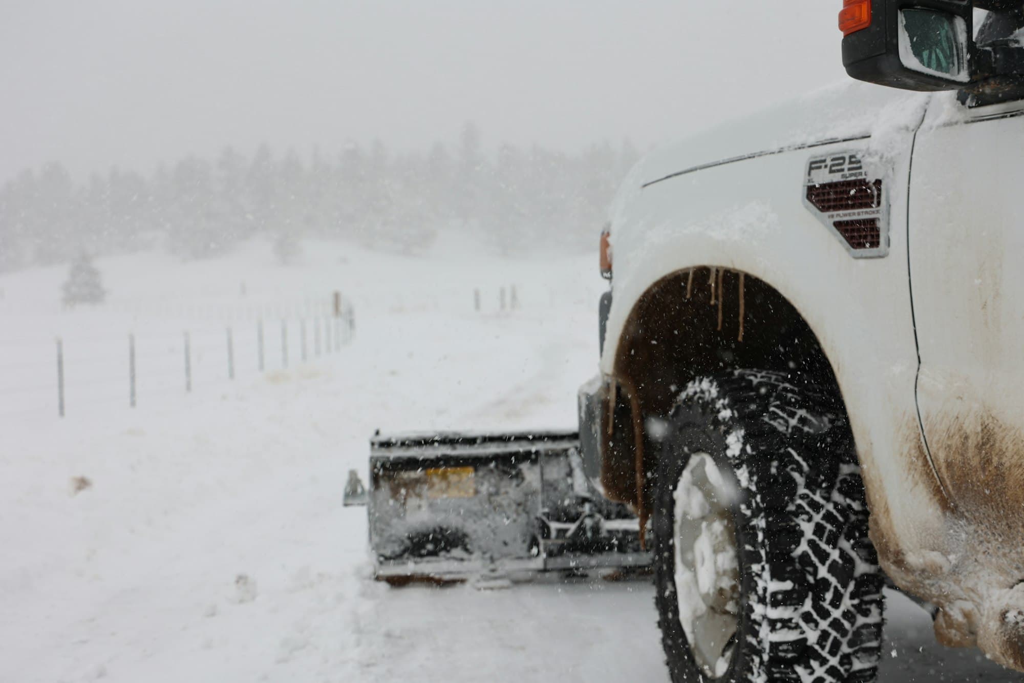 Pickup truck with a plow clearing snow